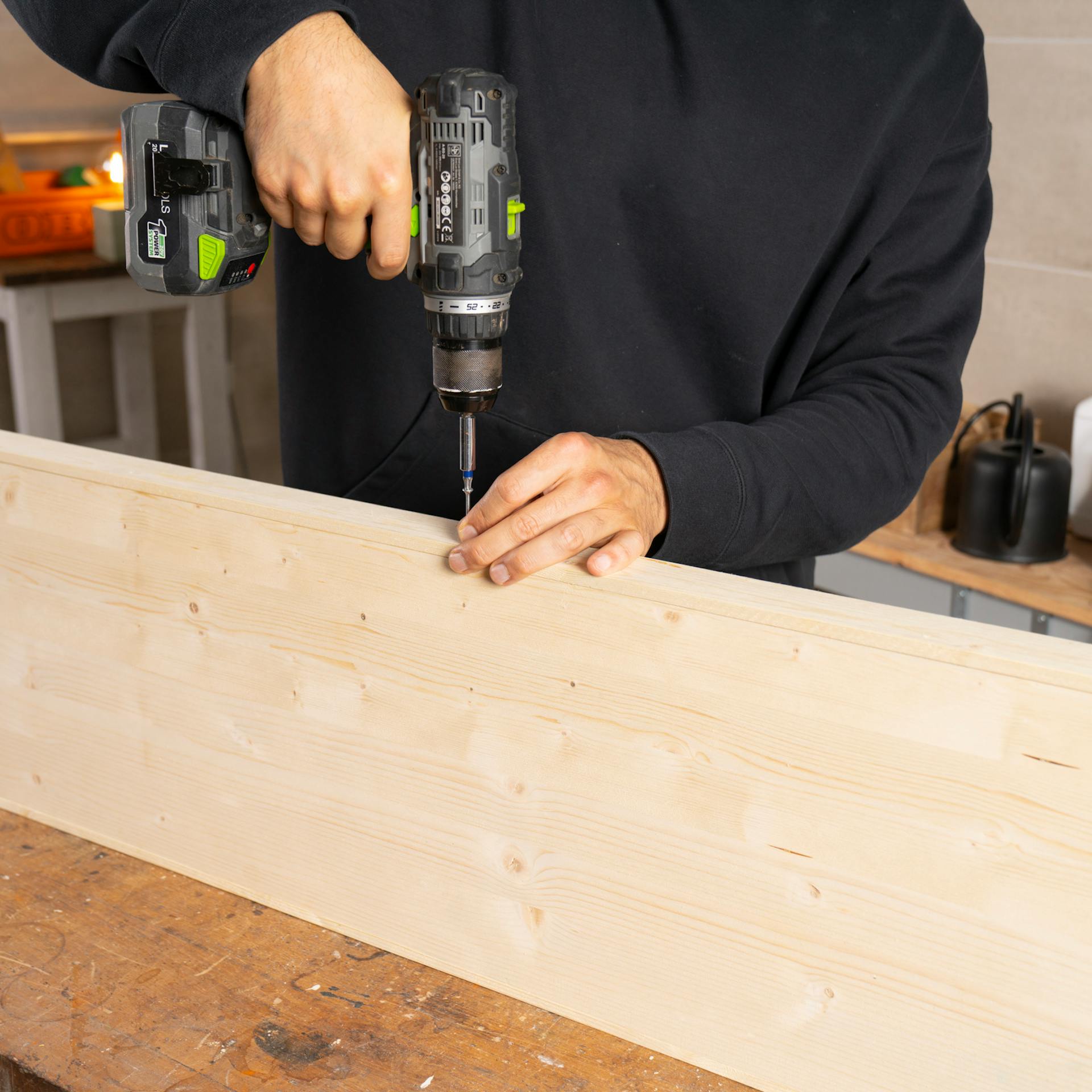 Základná doska sa položí na bok, aby sa k nej mohli priskrutkovať bočné diely.