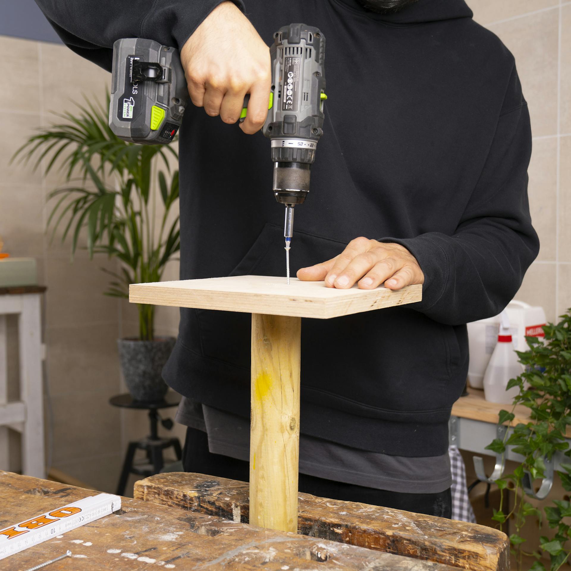 Doska stojana je priskrutkovaná k drevenému stĺpiku. Na tento účel sa do dreva zaskrutkuje skrutka pomocou akumulátorového skrutkovača.