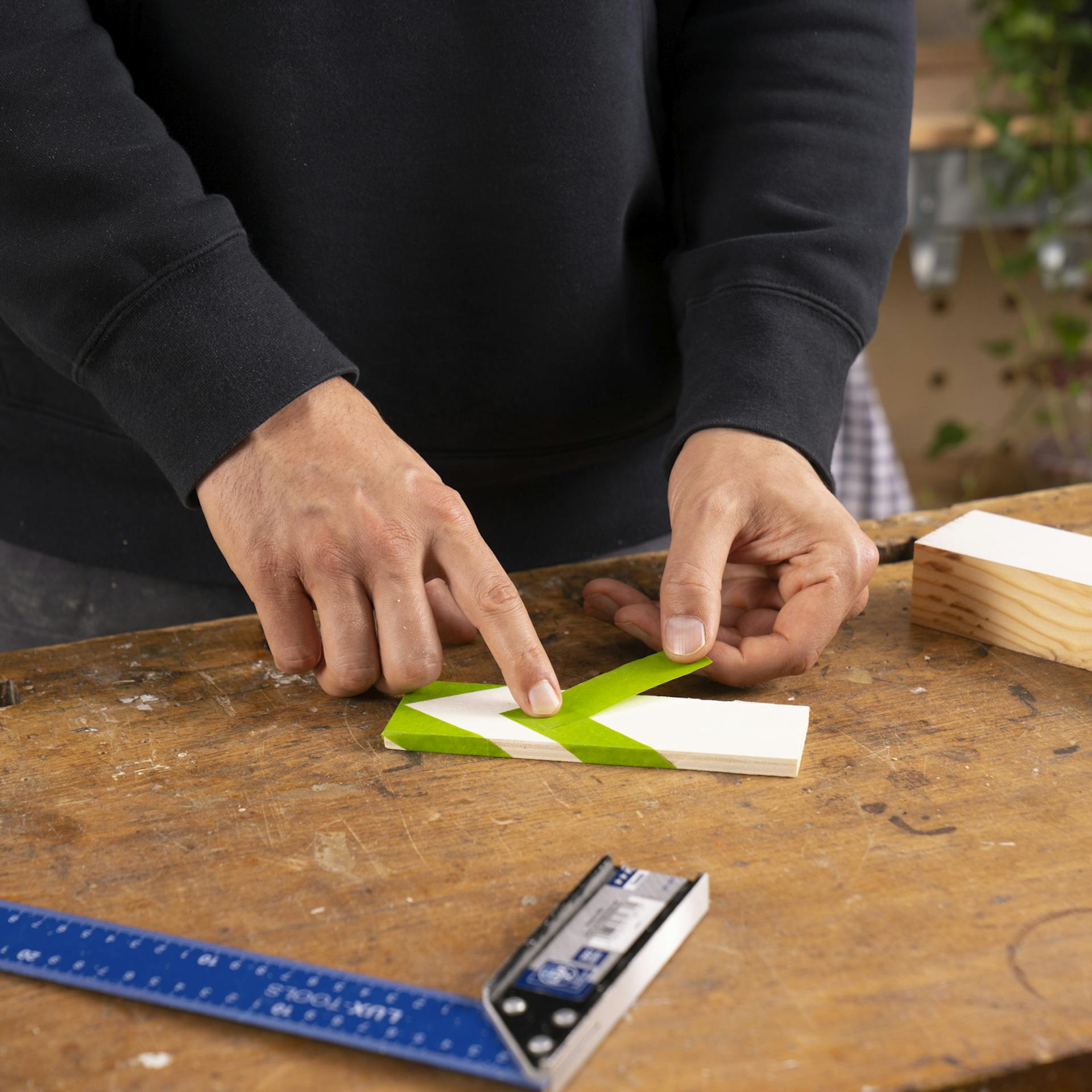 Veko saní s bielym základným náterom je maskované maskovacou páskou.