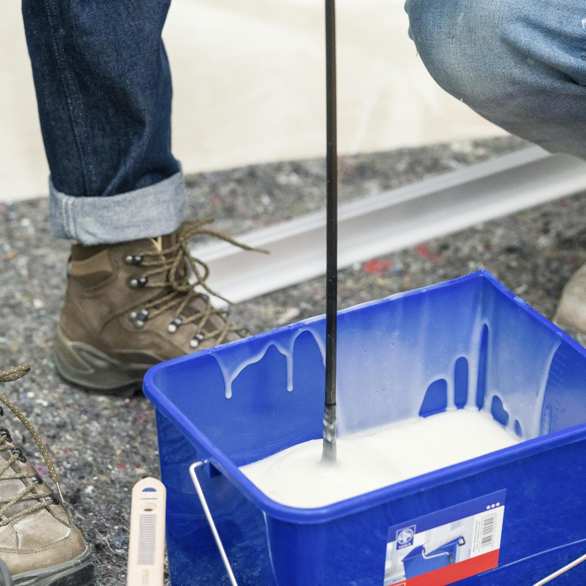 Zwei Personen rühren Tapetenkleister an.