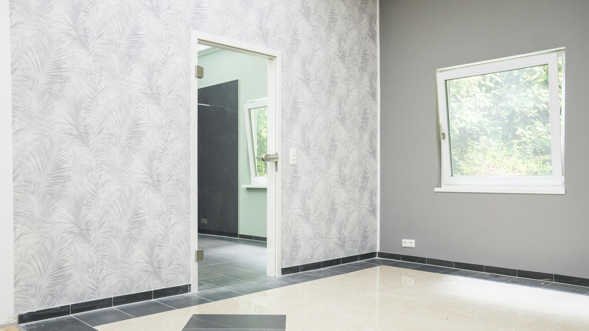 Raum mit Kombination aus grauer Mustertapete und grauer Wandfarbe