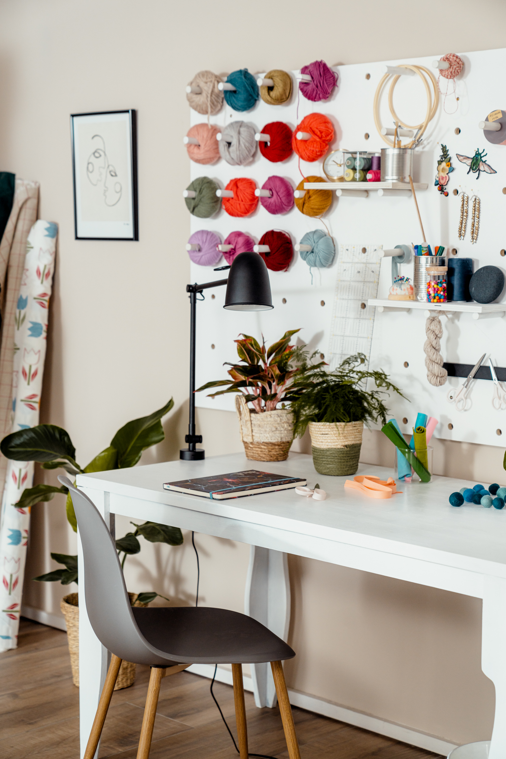 Schreibtisch mit Pegboard und Wollknäueln