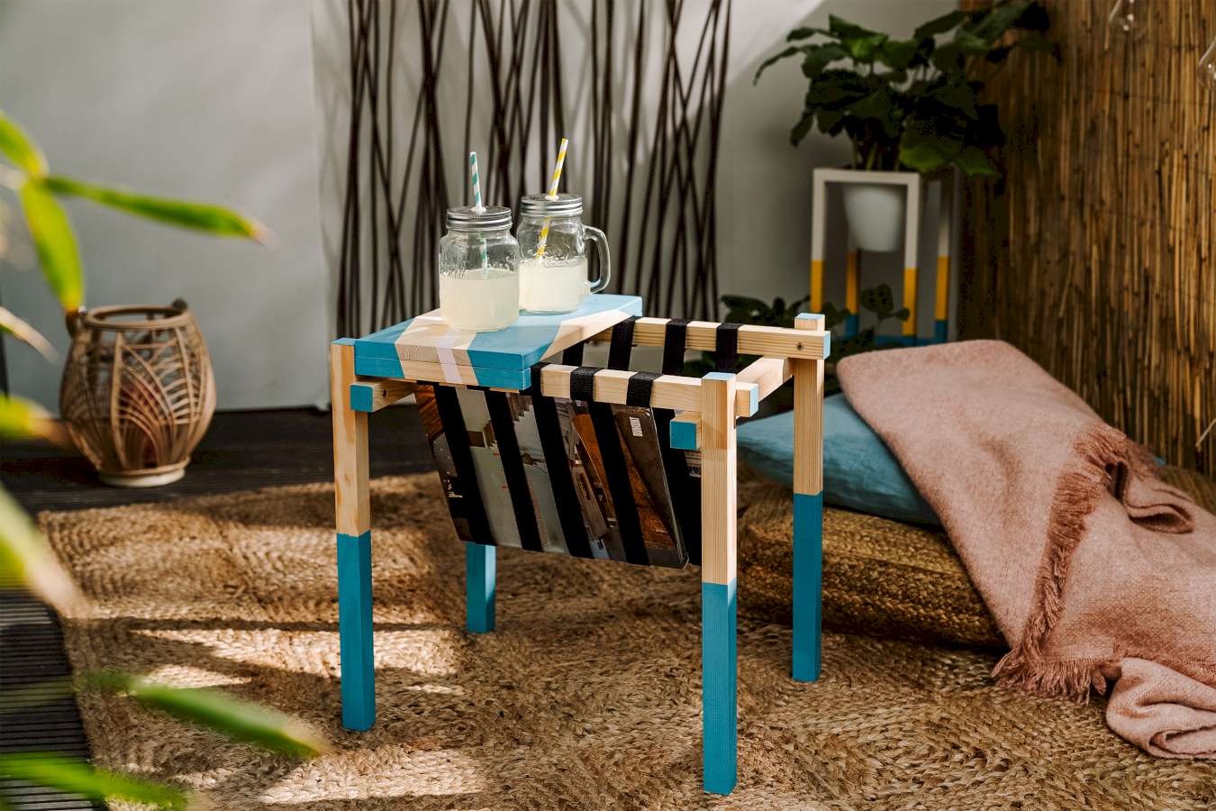 Ein DIY-Beistelltisch mit Magazinablage und blauem Muster aus Holz, auf dem Getränke stehen