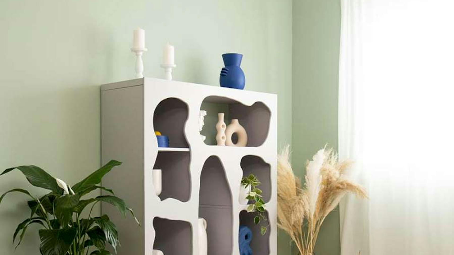 In einem Wohnzimmer steht ein Ikea KALLAX-Regal, das mit Putz gestaltet wurde