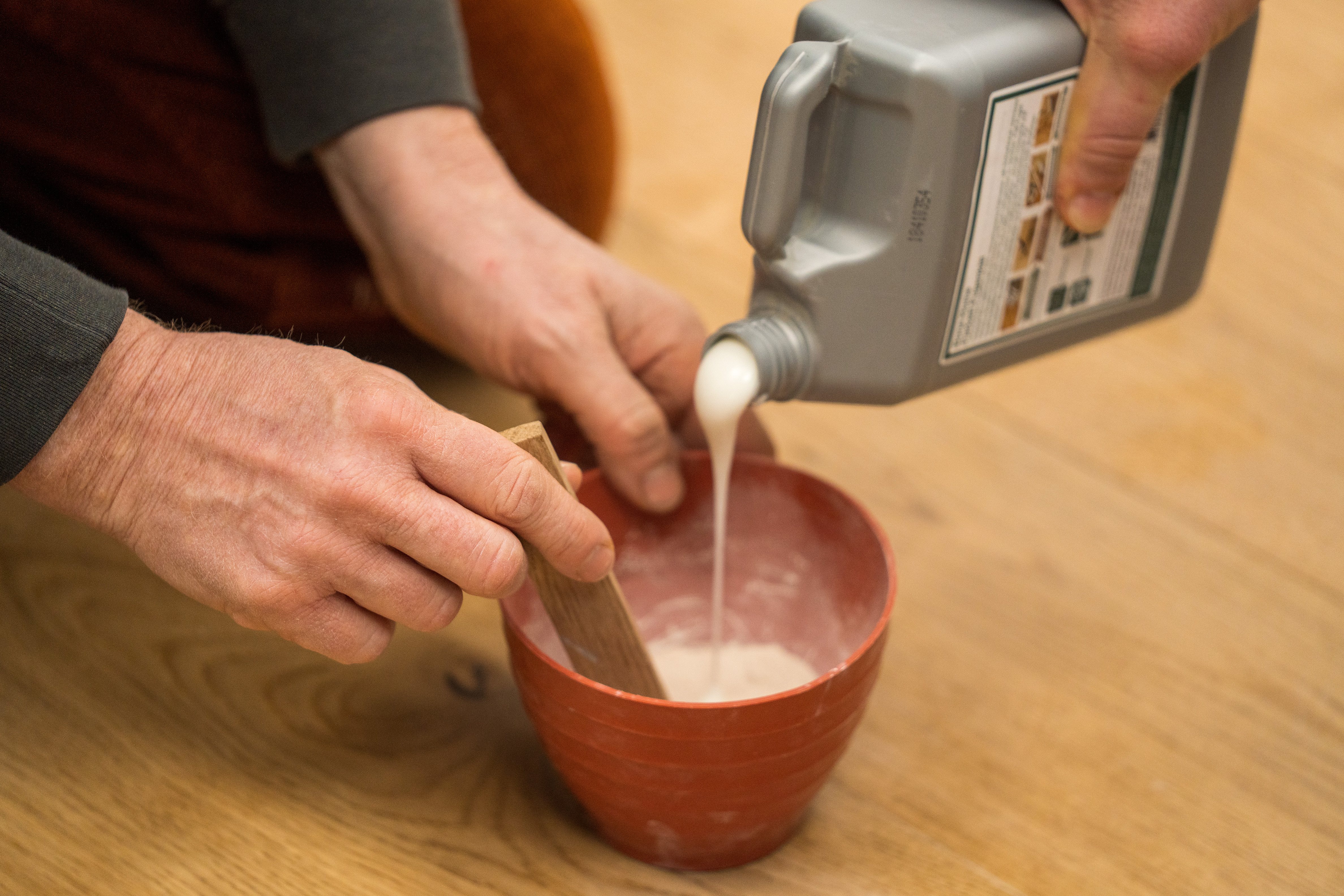 Una persona mescola stucco e segatura.