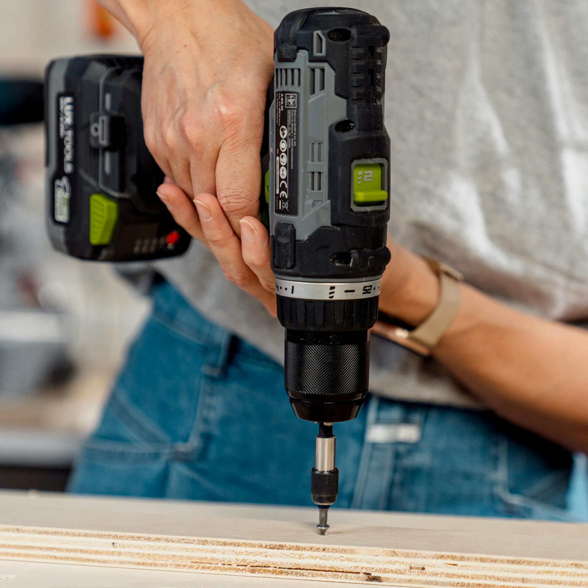 Person schraubt Abstandshalter auf Pegboard.