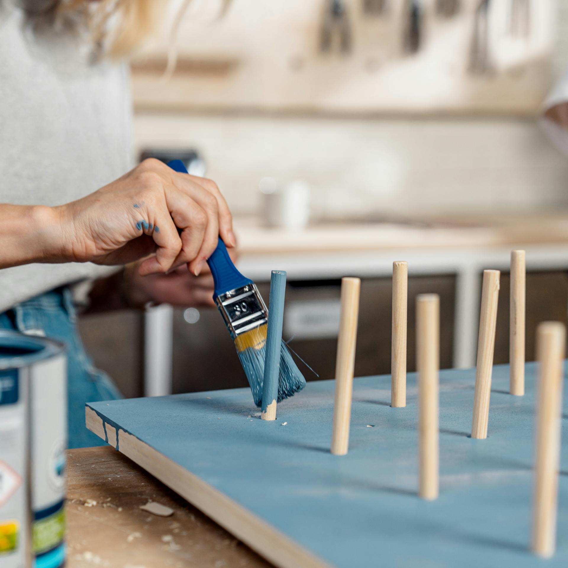 Person lackiert das Pegboard.