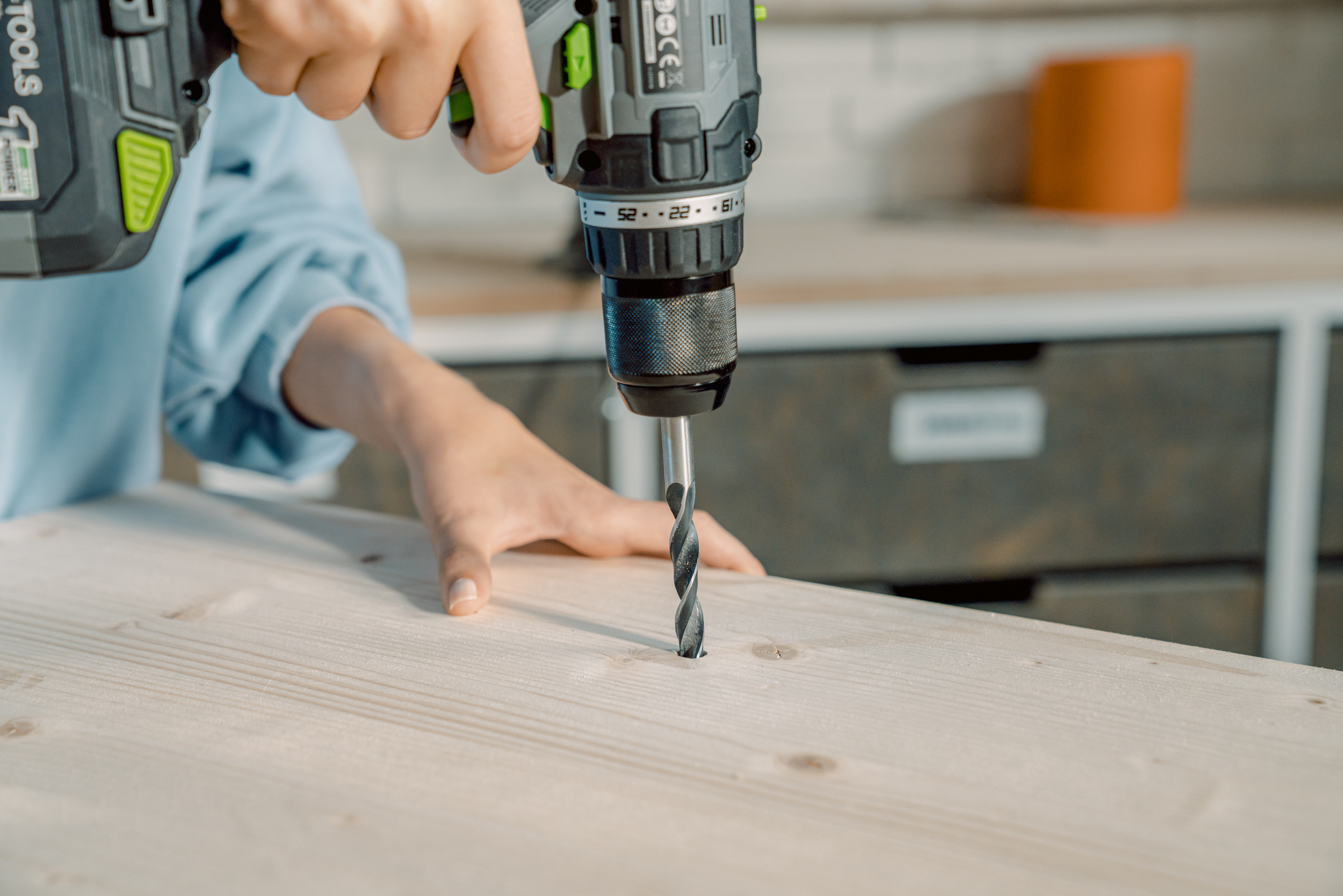 Ein Loch wird in eine Holzplatte gebohrt