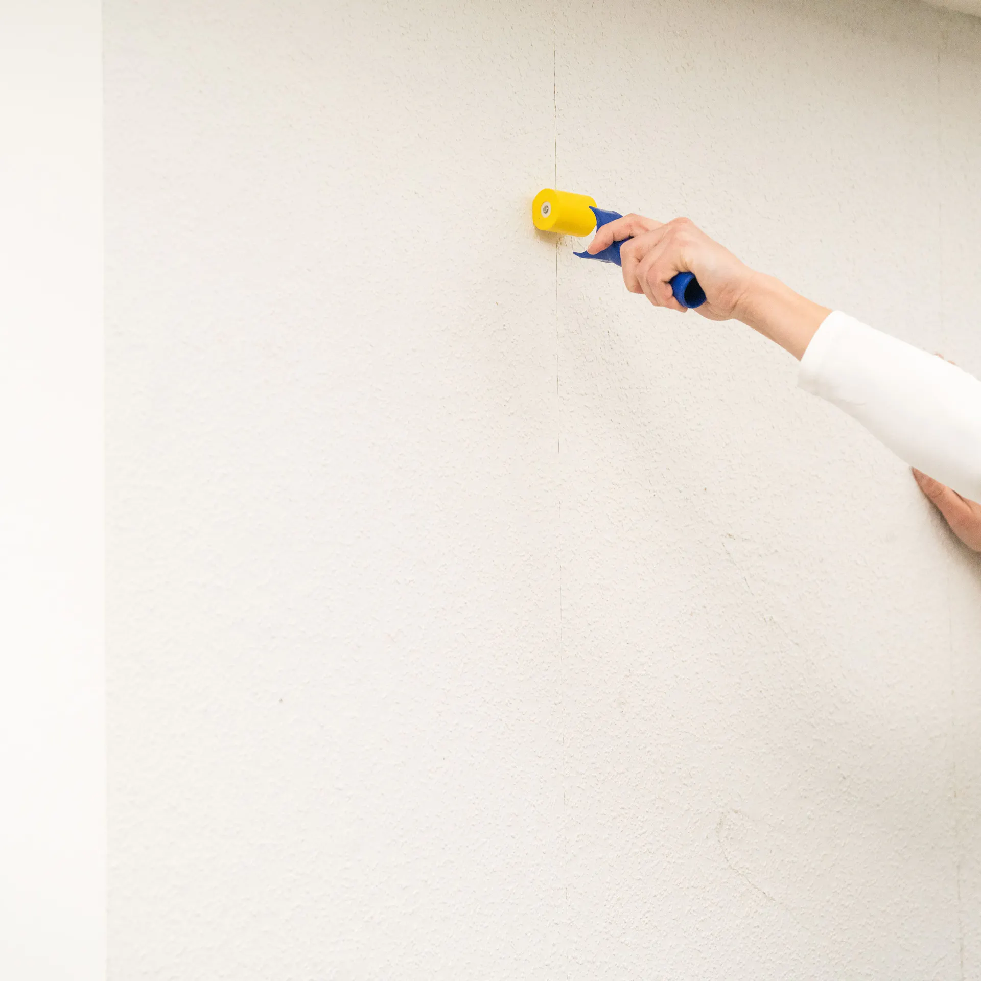 Někdo přitlačuje švy pomocí přítlačného válečku.