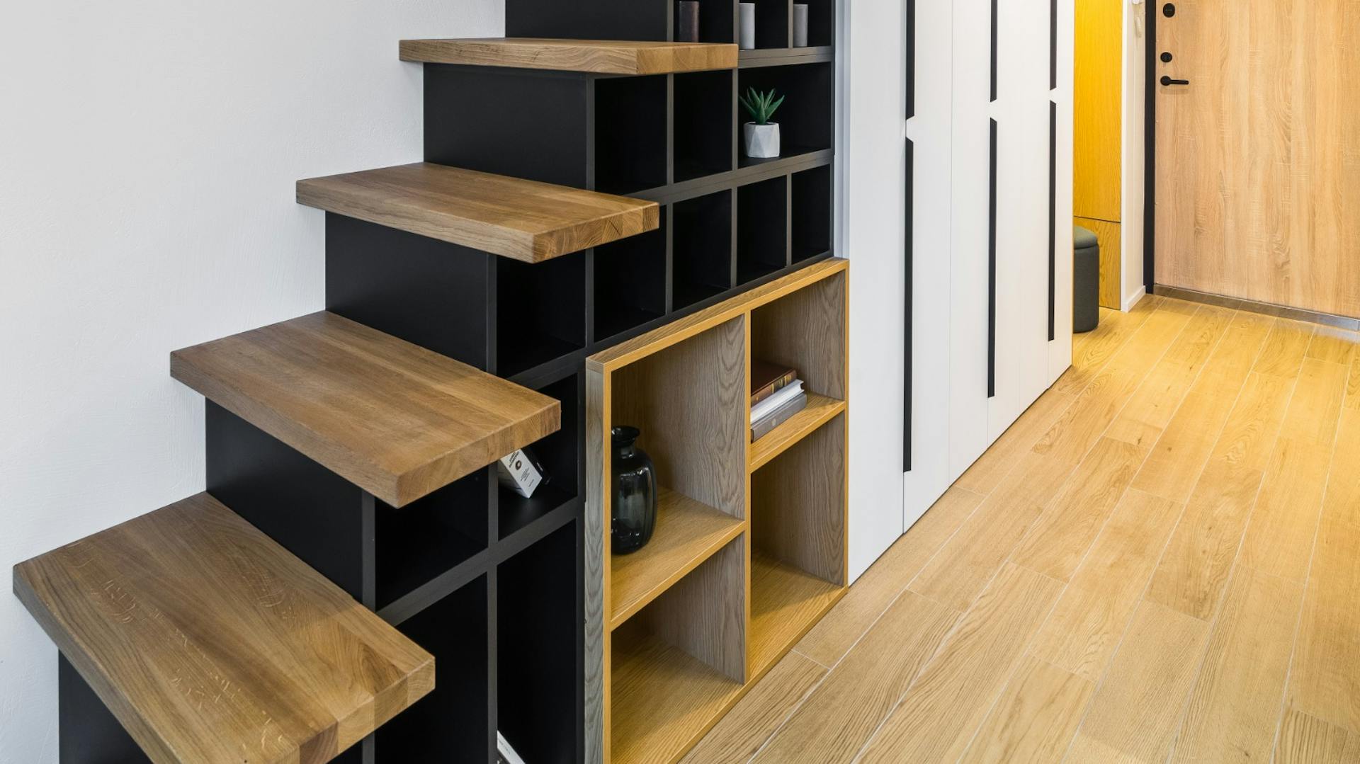 Schwarzes Treppenregal mit Holzstufen