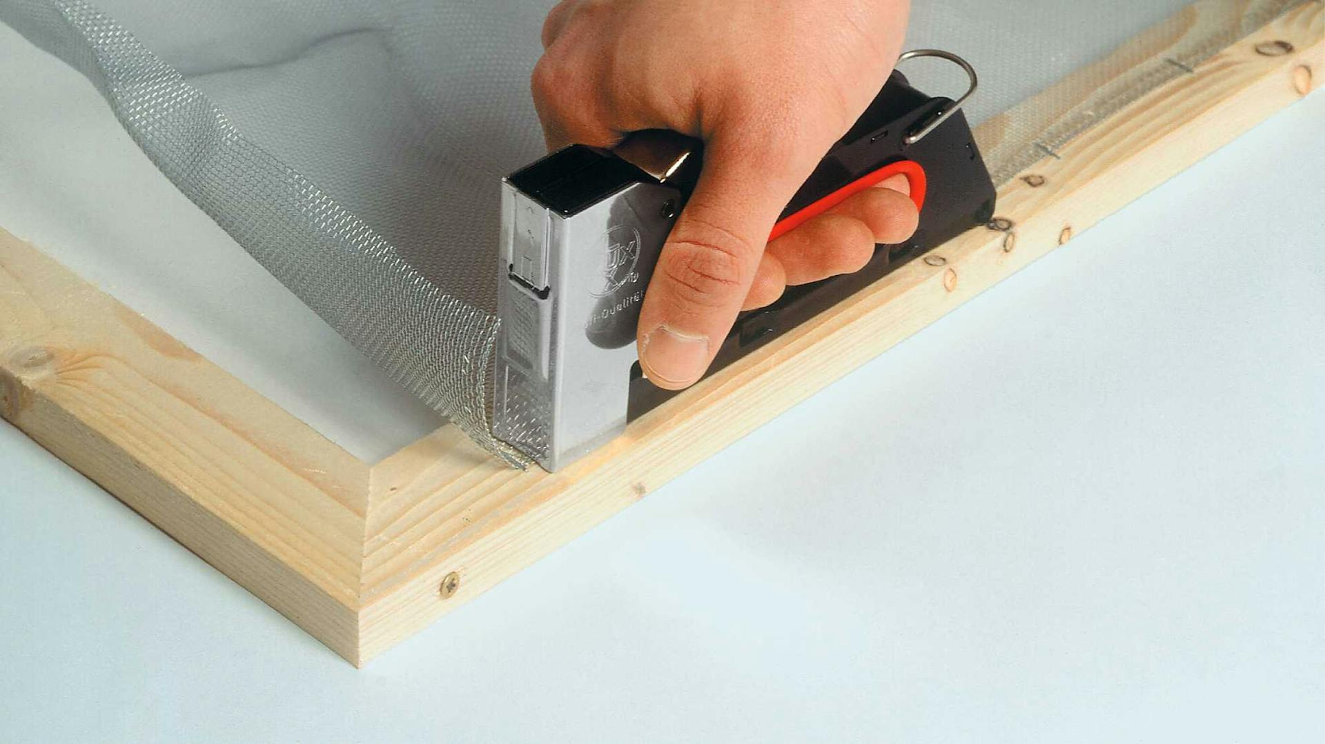 Hand mit Tacker auf Rahmen