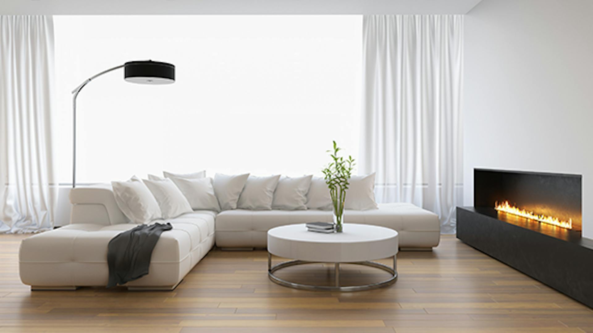 Soggiorno luminoso con divano bianco e stufa caminetto a gas davanti alla finestra