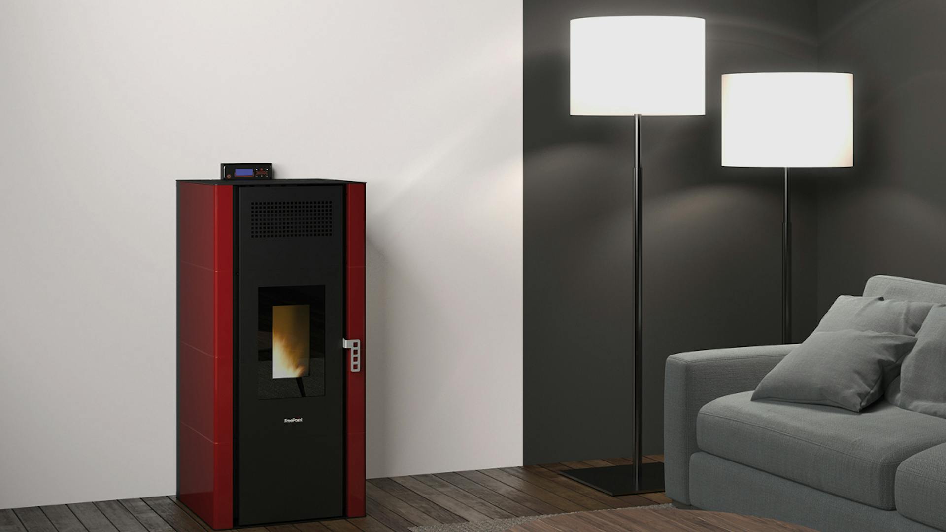 Una stufa a pellet rossa di fronte a una parete bianca in un soggiorno con pavimento in legno scuro e pareti alte.