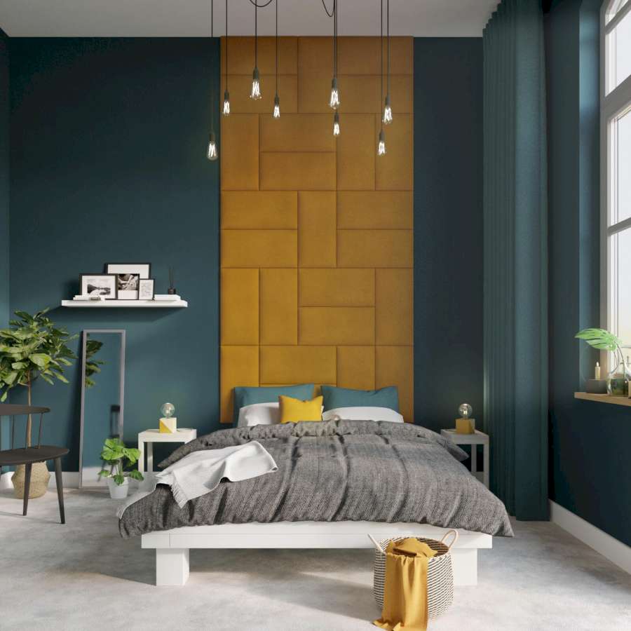Vor einer gelb-grünen Wand steht ein Bett mit gelben und grünen Kissen.