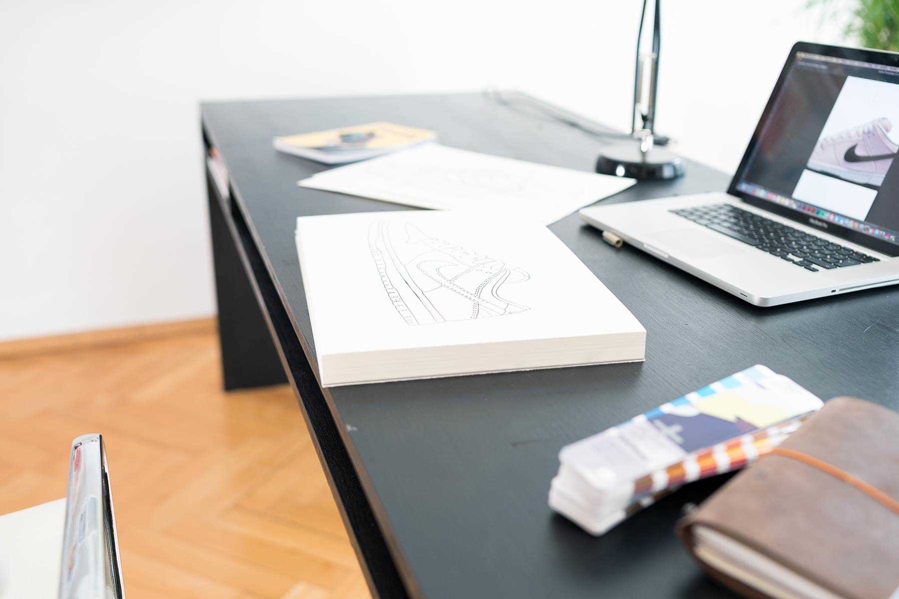 Seitliche Ansicht des aus Vollholz bestehenden Schreibtisch Otto in schwarz mit viel Arbeitsfläche.