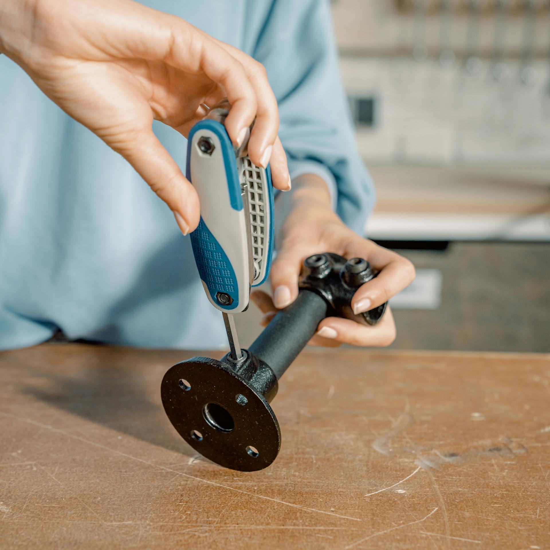 Frau verbindet Stahlrohr mit einem Sechskantschlüssel