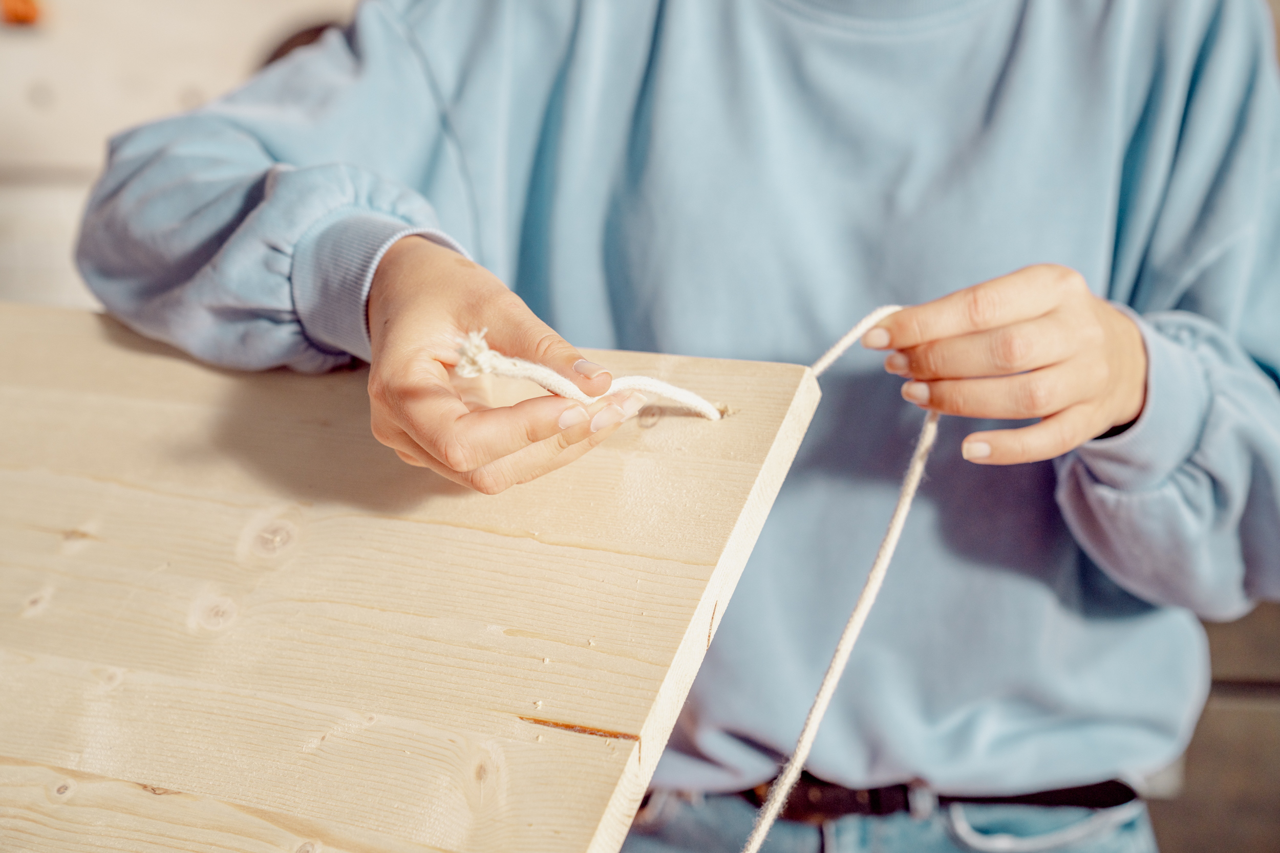 Seile in die Löcher der Platte einfädeln