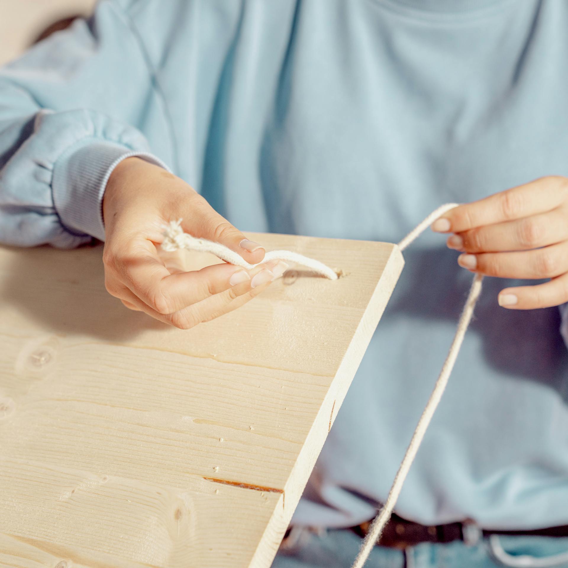 Seile in die Löcher der Platte einfädeln