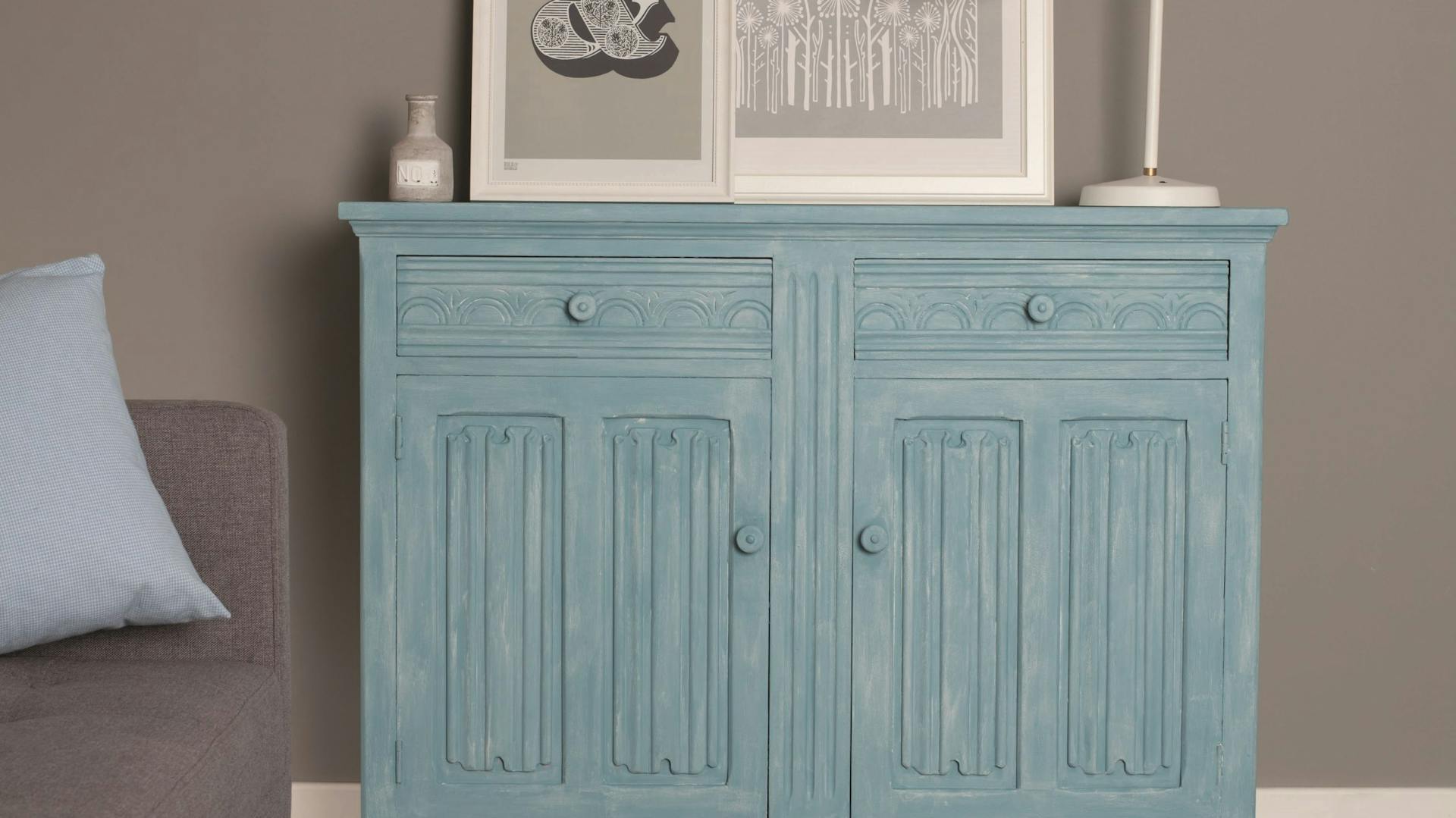 DIY Shabby-Chic-Sideboard mit blauer Kreidefarbe, auf dem Bilderrahmen und Lampe stehen