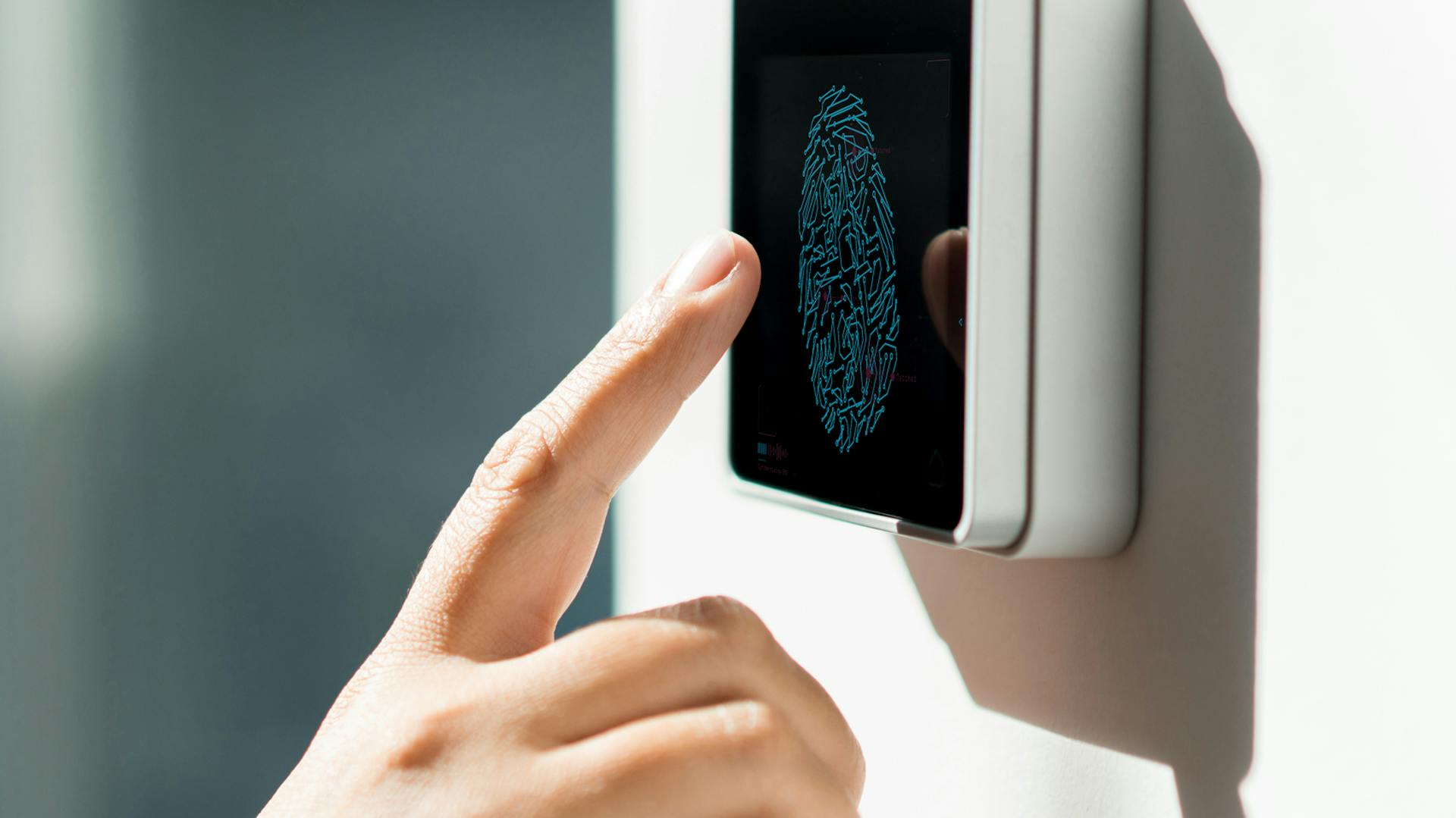 Person bedient Smart-Home-Regler, der an Wand angebracht ist.