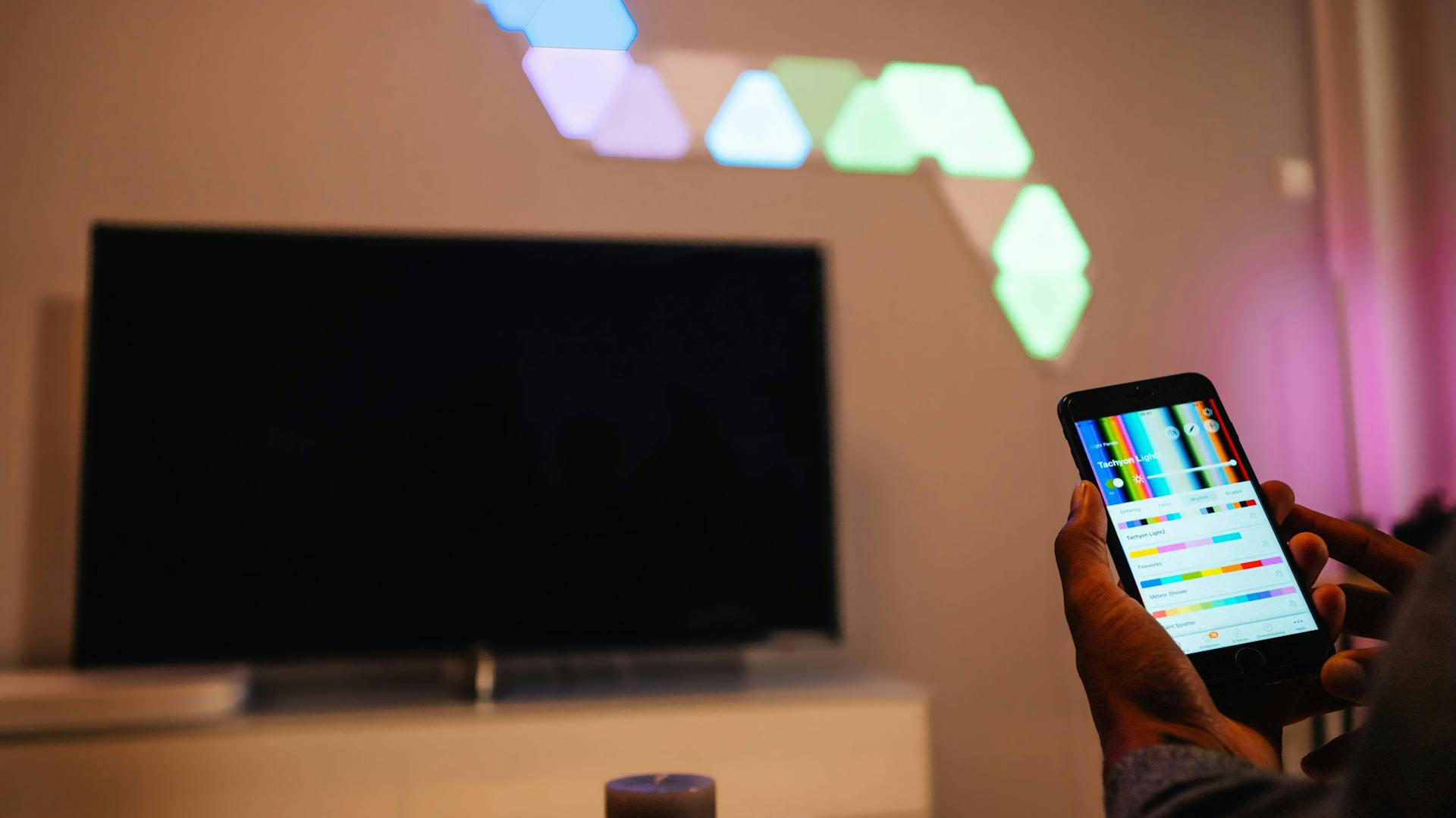 Egy férfi alkalmazás segítségével vezérli a fal megvilágításának színét