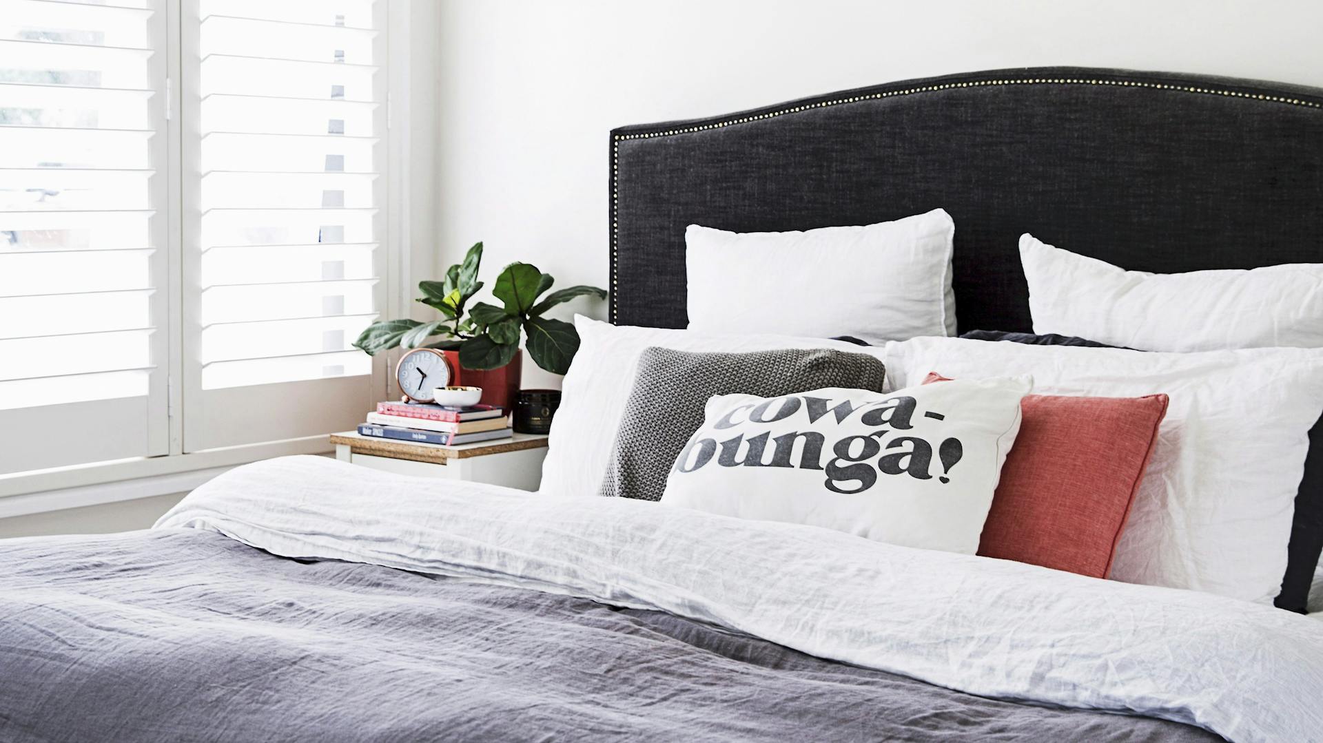 Ein Bett im Schlafzimmer mit einem darüber hängenden Ventilator.