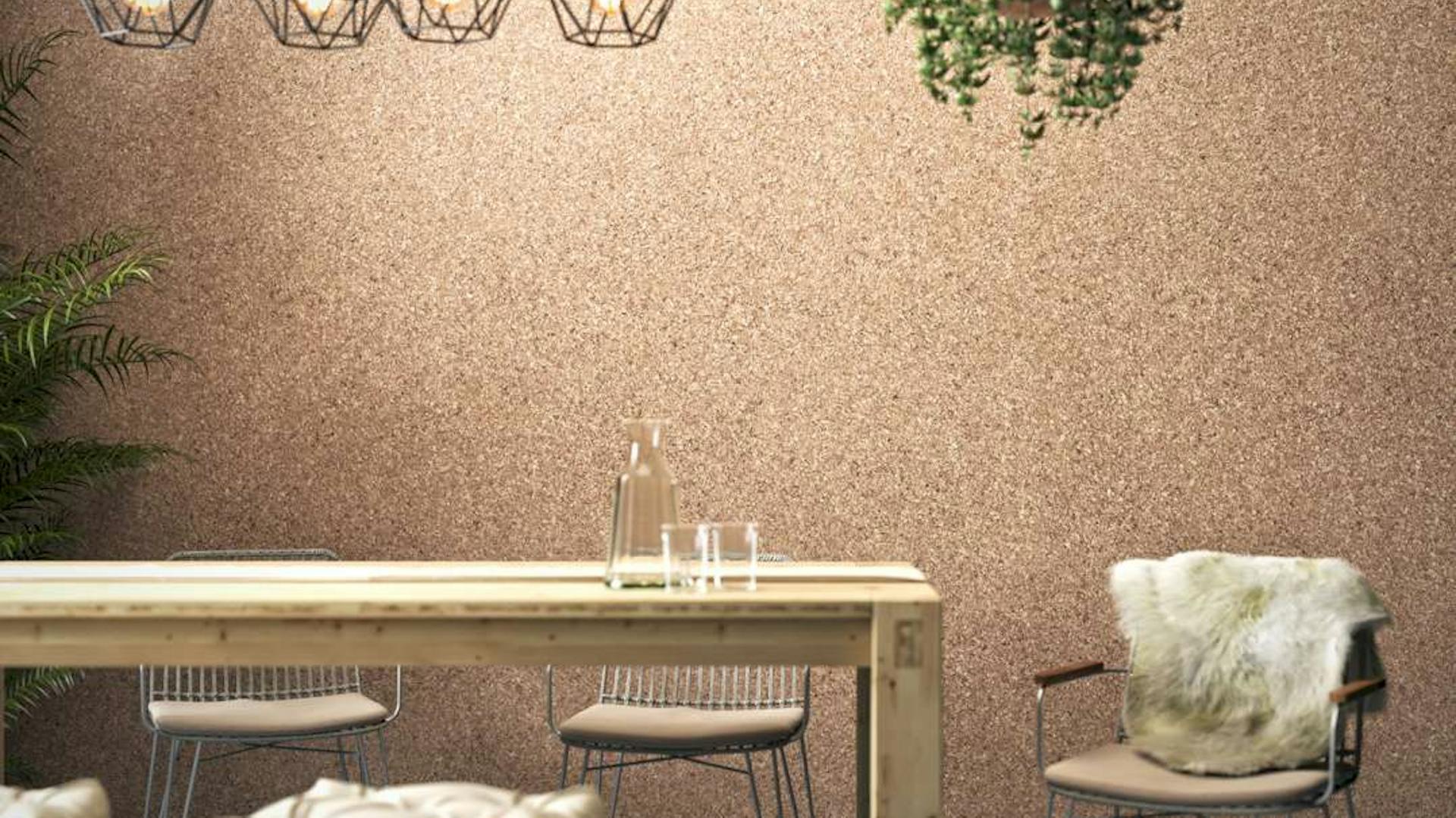 Tisch Maren aus hellem Holz steht vor einer kompletten Korkwand.