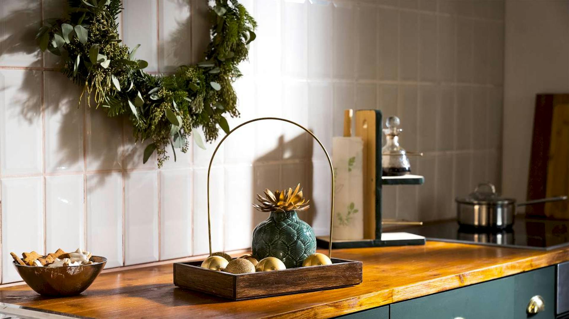 Auf einer Arbeitsplatte in einer Küche wurde ein DIY-Tablett mit Griff platziert, auf dem sich Dekoration befindet