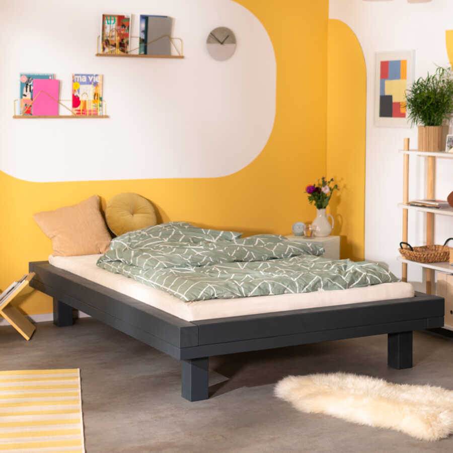 In einem Schlafzimmer mit weiß-gelben Wänden steht Bett Ludwig.