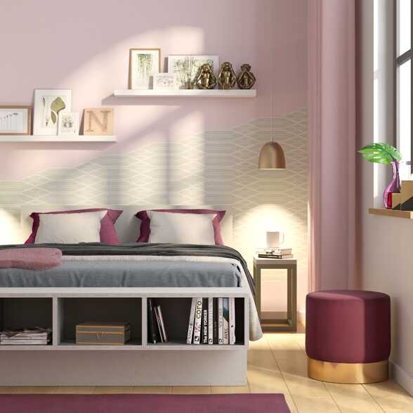 In einem Schlafzimmer befindet sich an der rosa Wand hinter dem Bett eine Form aus Tapete in Beige.