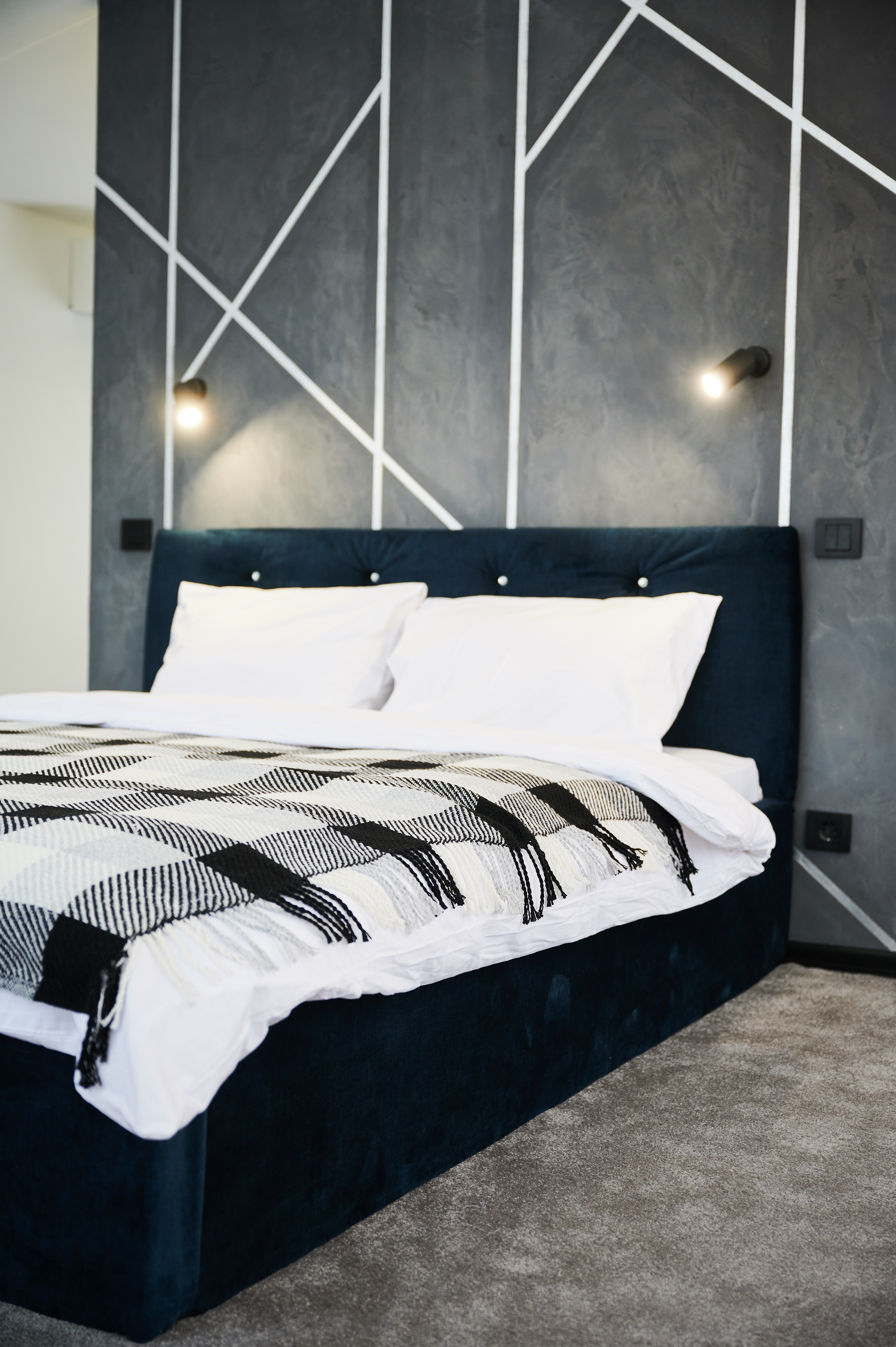 Schlafzimmer mit moderner dunkler Tapete mit weißem geometrischem Muster