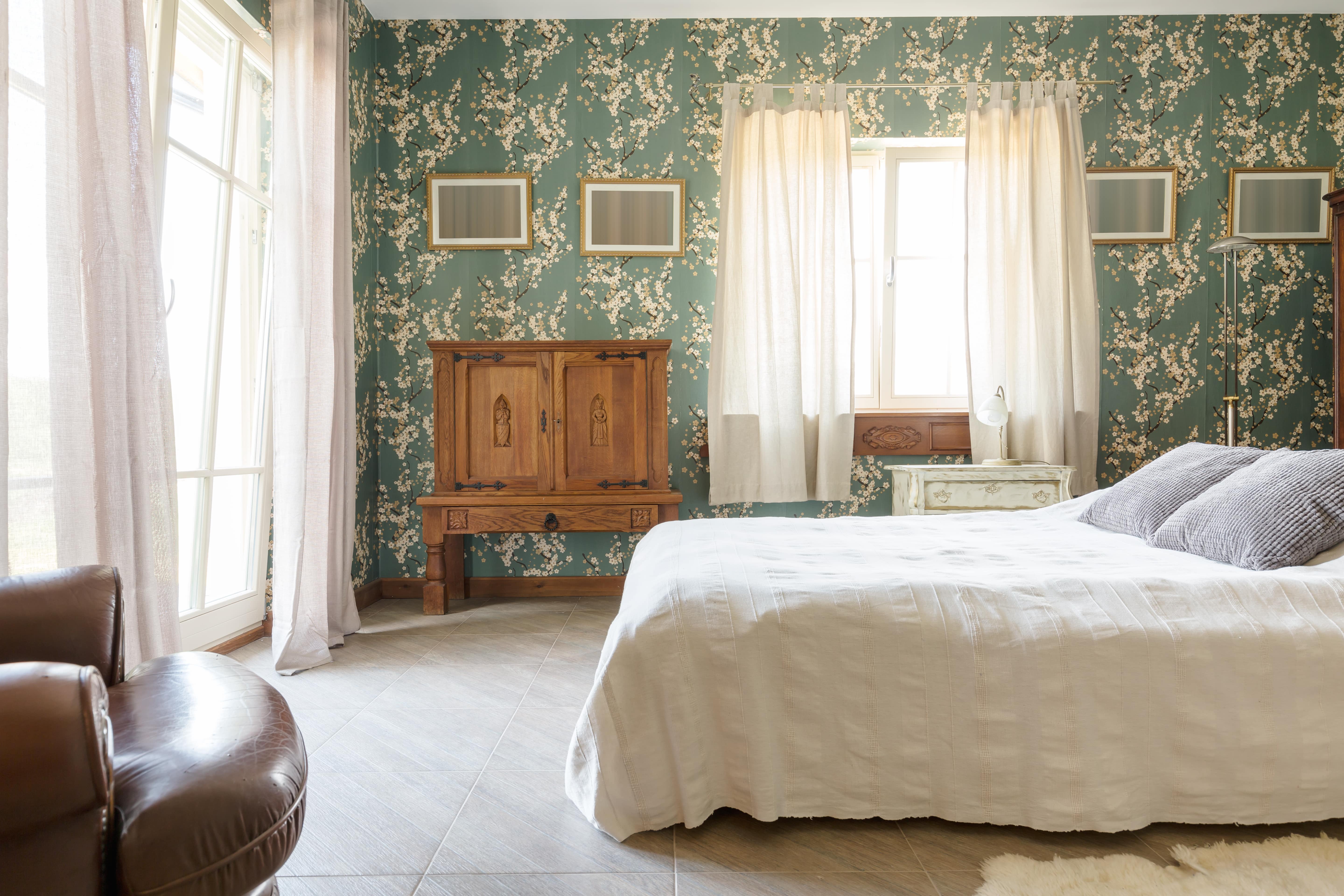 Schlafzimmer im Landhausstil mit grüner Ornamenttapete