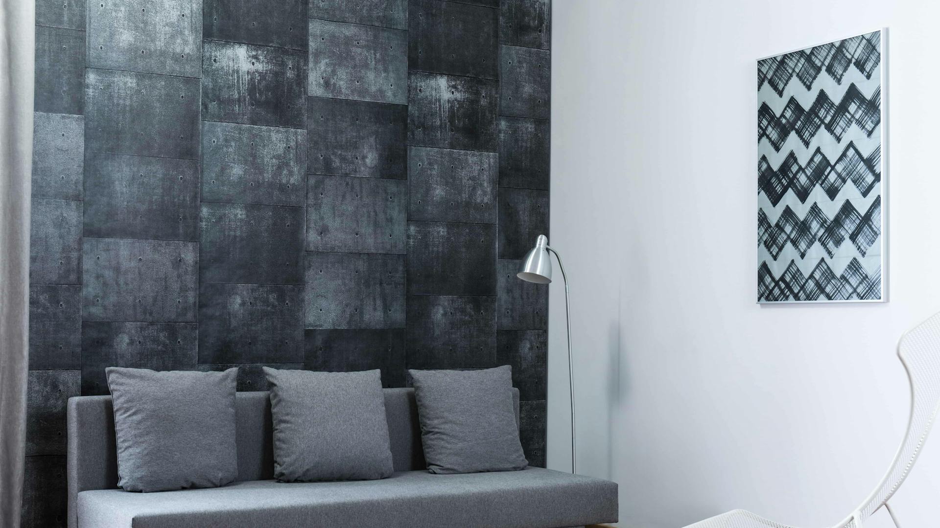 Schwarze Tapete mit Muster in Wohnzimmer mit grauer Couch