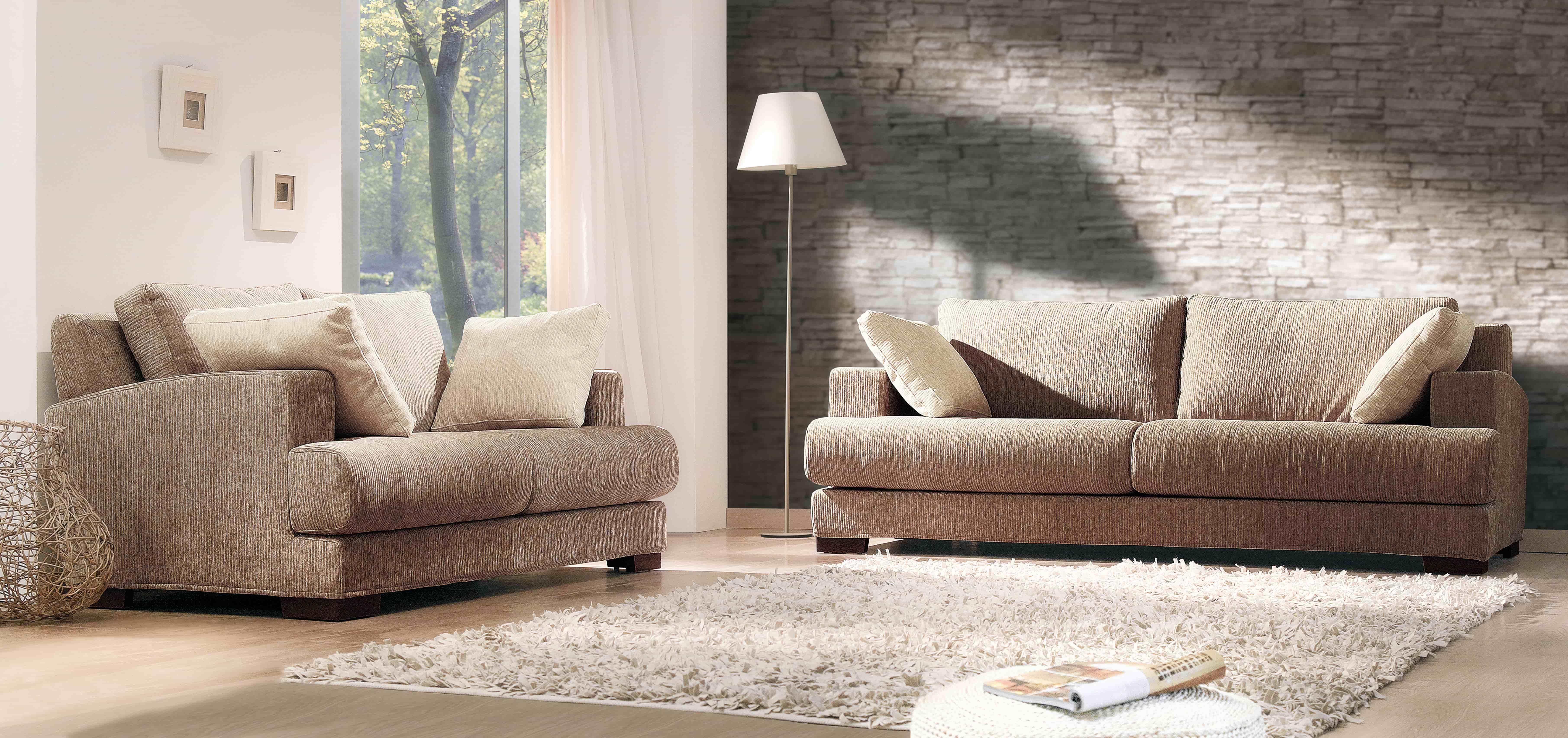 Sofas vor einer Tapete mit Mauermotiv.