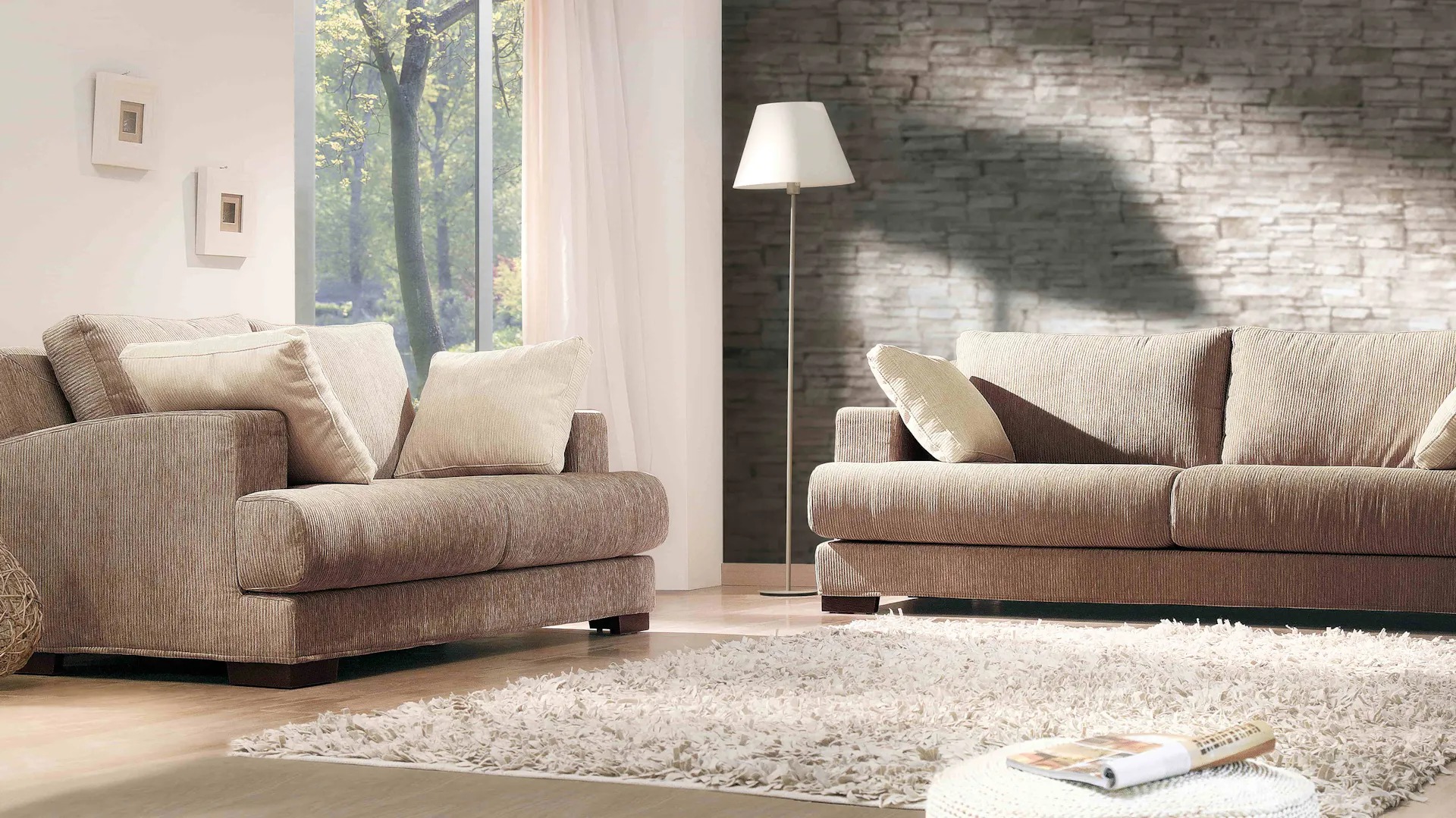 Sofas vor einer Tapete mit Mauermotiv.