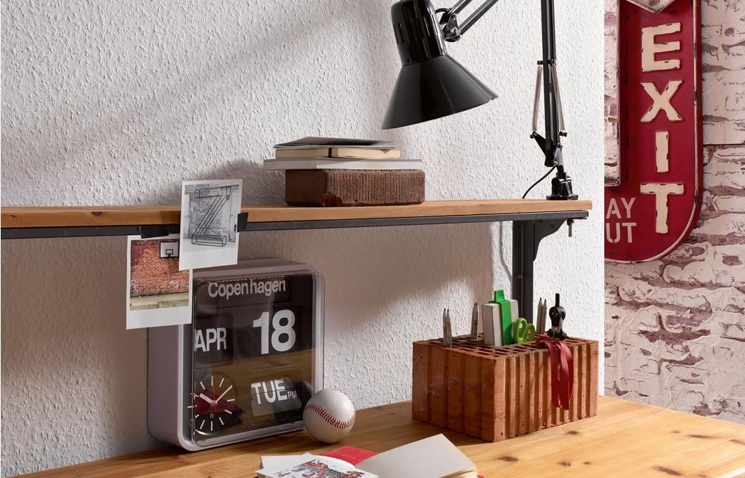 Raufasertapete an der Wand hinter Schreibtisch mit Wecker, Notizzetteln und Schreibtischlampe