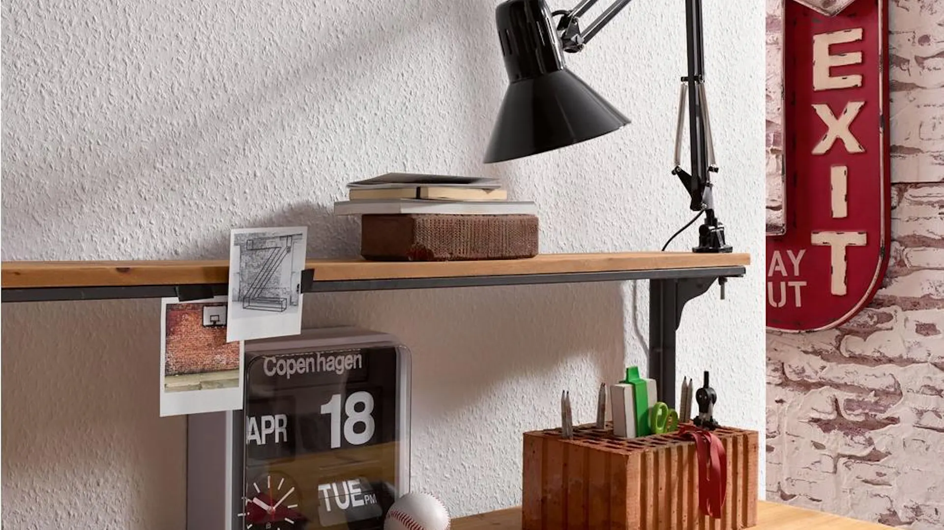 Raufasertapete an der Wand hinter Schreibtisch mit Wecker, Notizzetteln und Schreibtischlampe