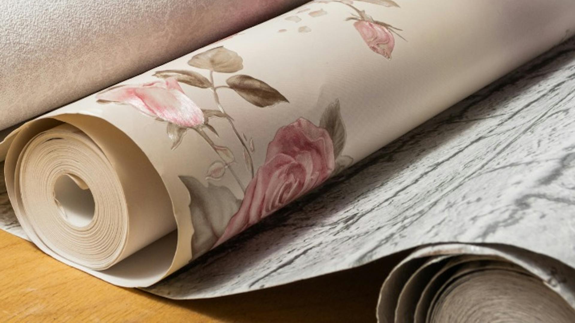 Verschiedene Tapetenrollen mit Muster auf einem Tapeziertisch