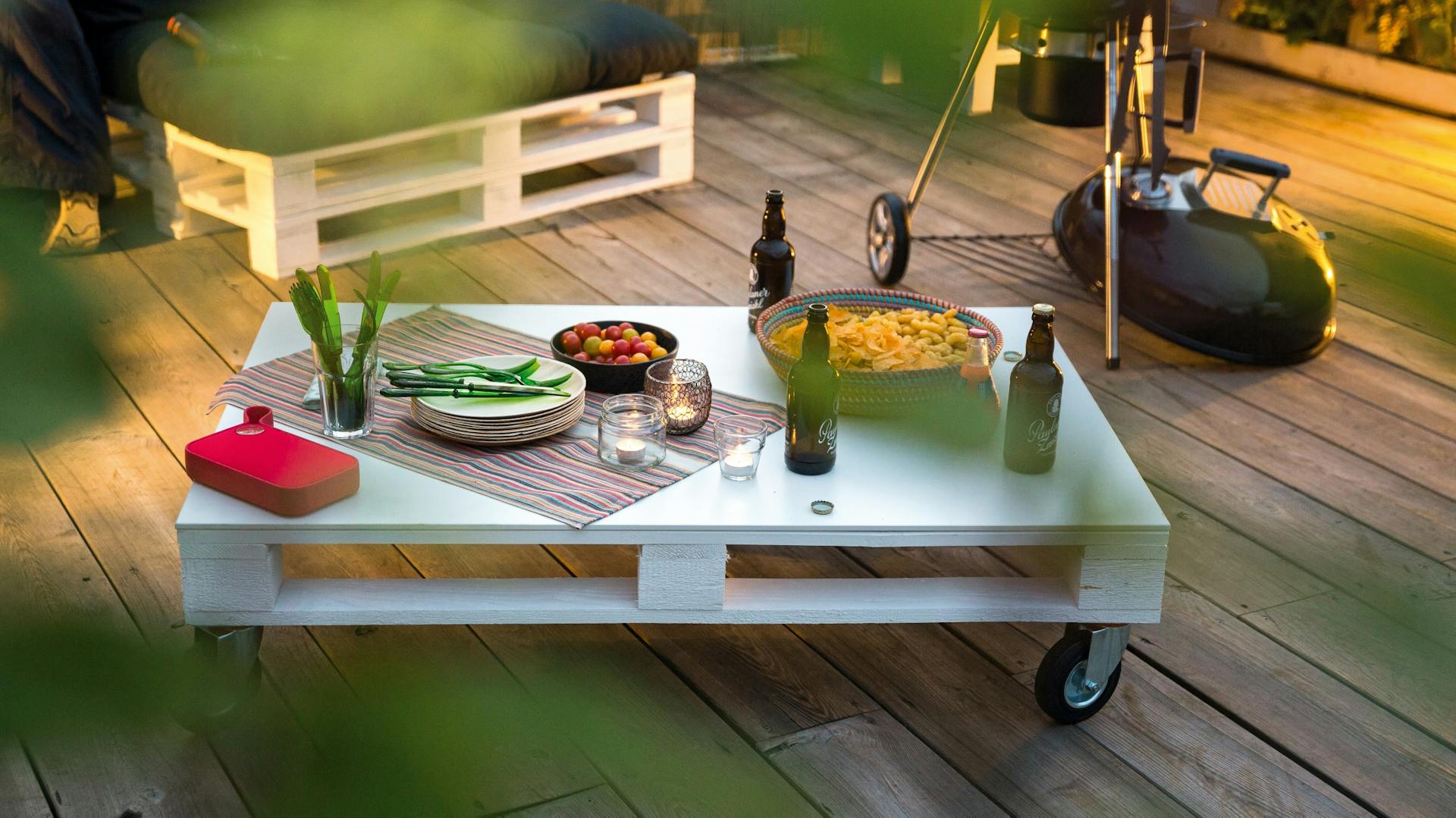 Tavolino da salotto blu fatto con palette con ruote sulla terrazza in giardino