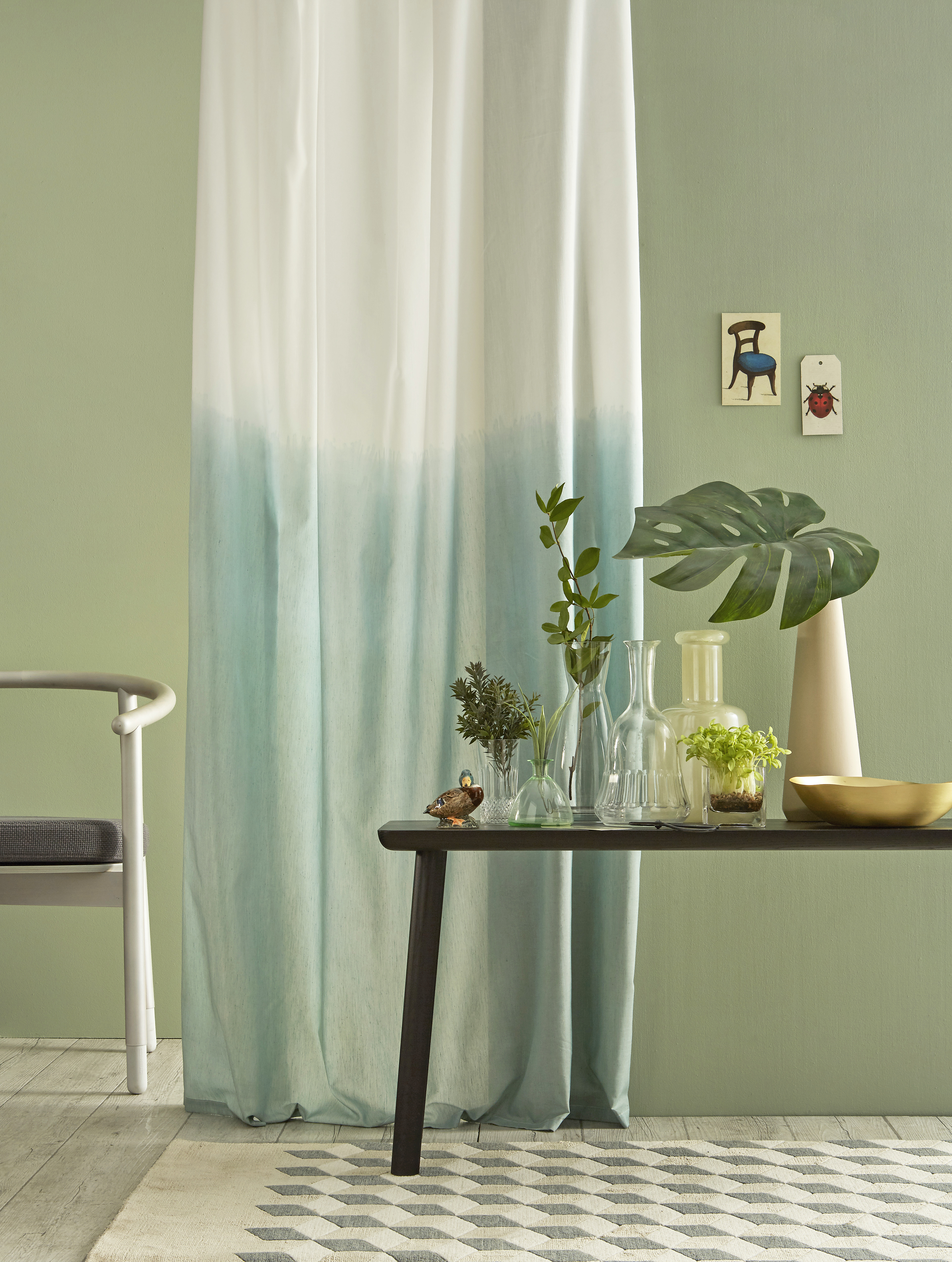 Una parete verde con oggetti decorativi davanti.