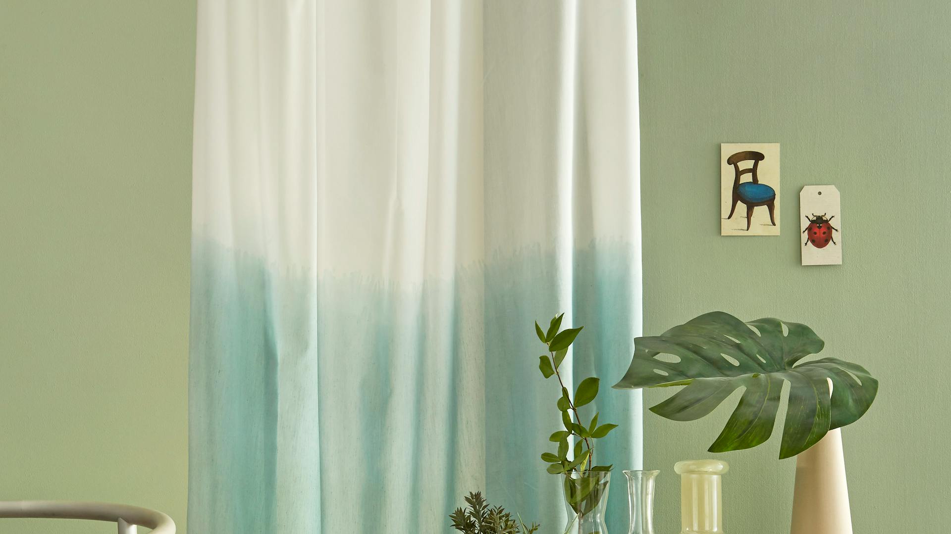 Una parete verde con oggetti decorativi davanti.