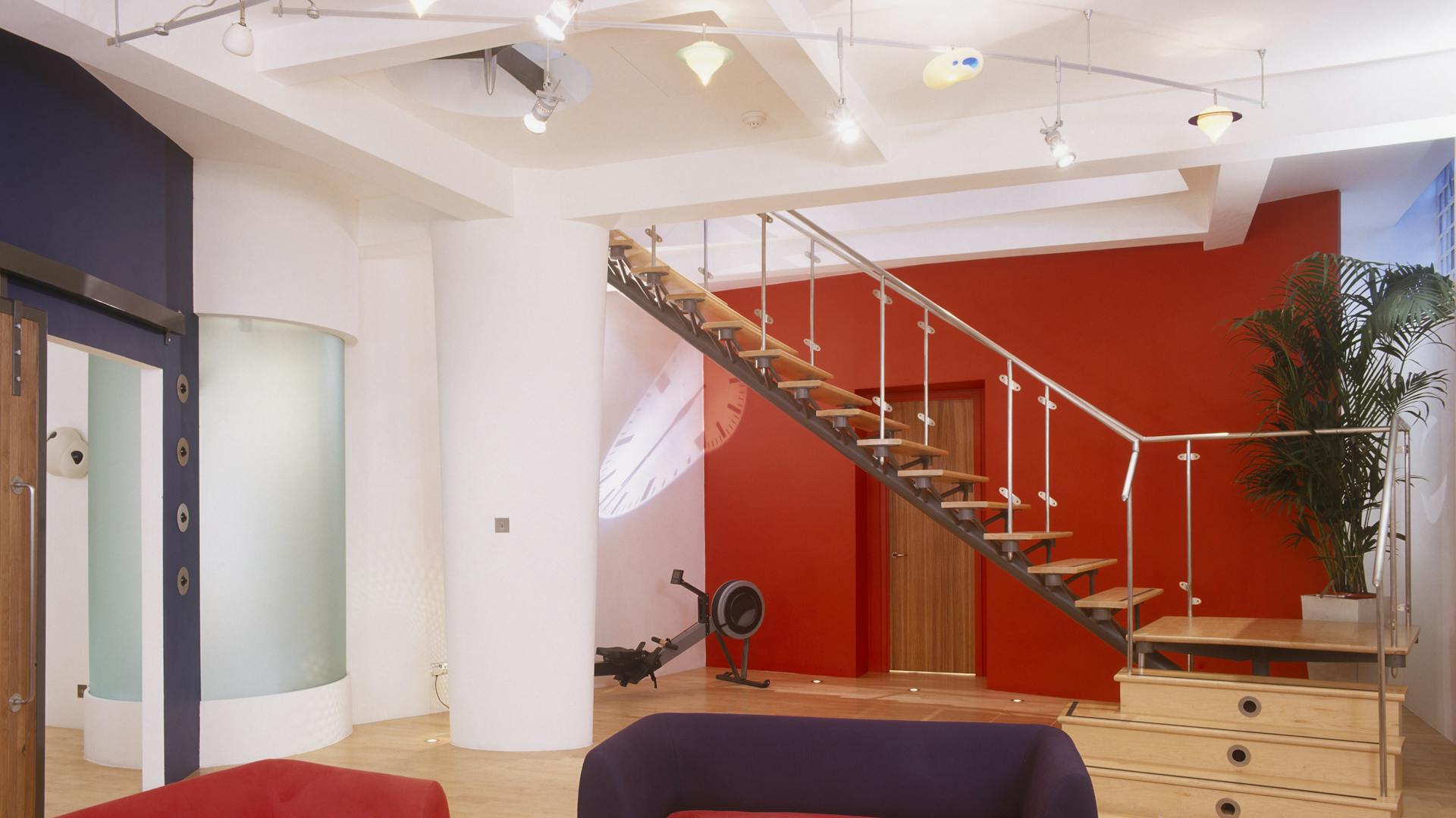 Un salotto con una parete rossa e mobili dal colore abbinato