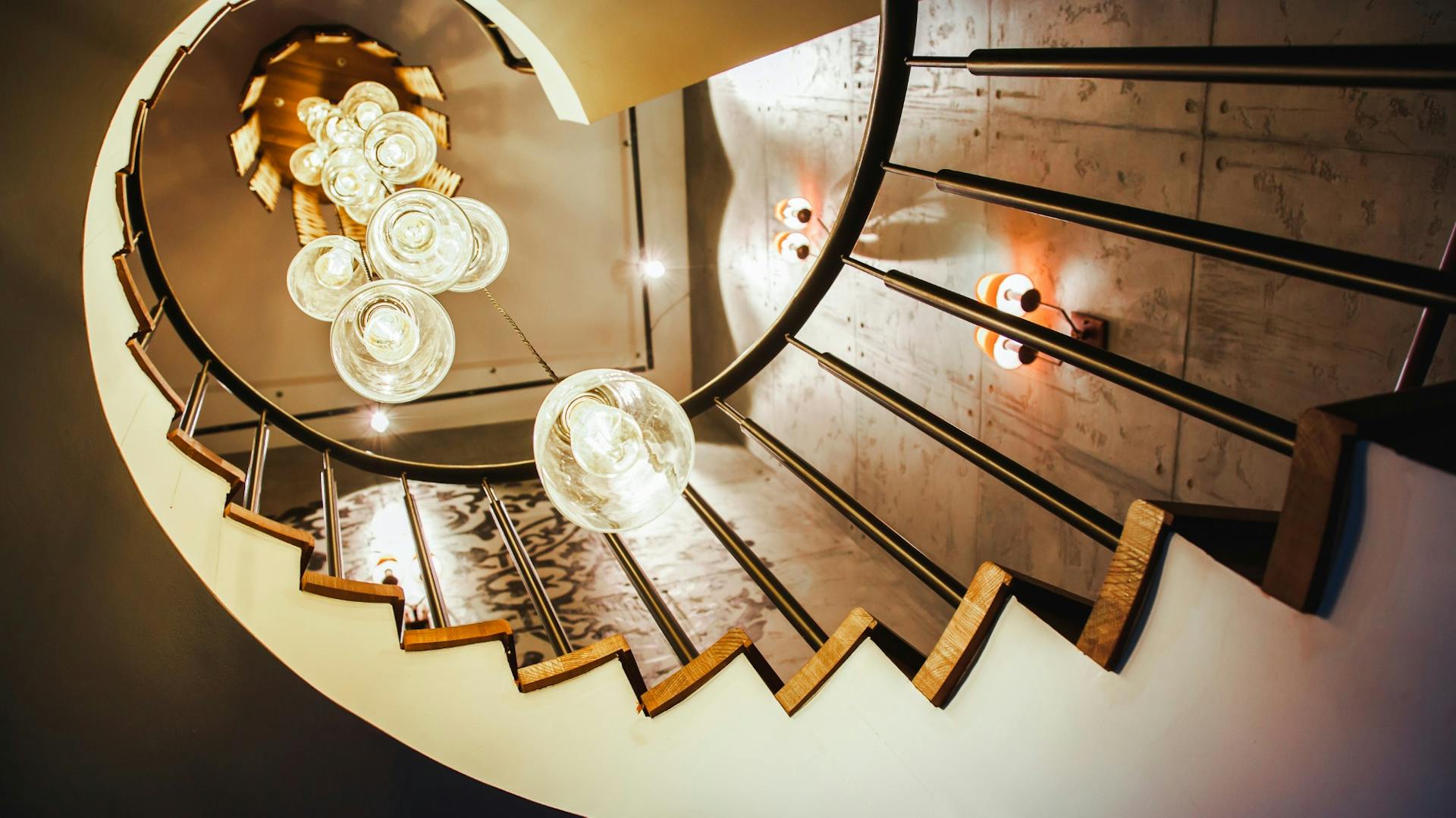 Wendeltreppe mit Wand- und Hängelampen