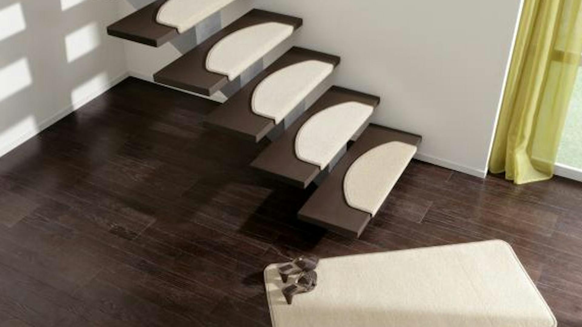 Holztreppe im Haus mit weißen Treppenstufenmatten, davor liegt ein weißer Teppich mit einem Paar Schuhe darauf.