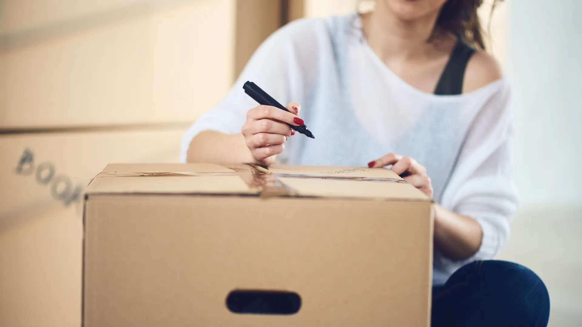 Una donna etichetta una scatola da trasloco