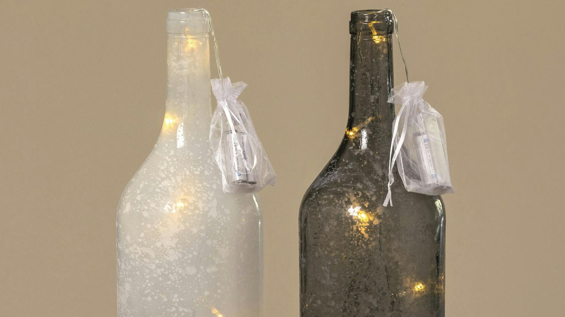 Bottiglie ripiene di ghirlande luminose, le batterie sono nascoste in un sacchetto appeso al collo della bottiglia.