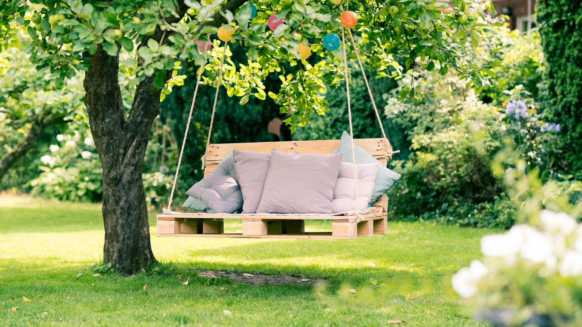 Da pallet e corde nasce un’altalena da giardino con cuscini.
