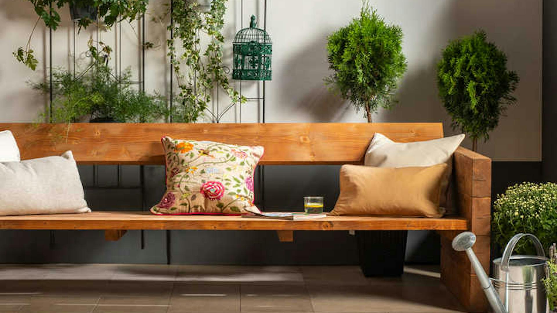 Gartenbank Jule in naturfarben, mit Dekokissen.