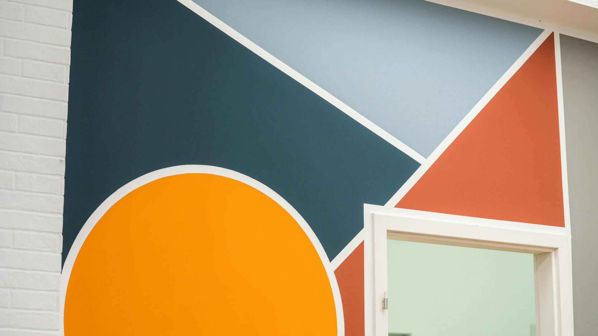 Gestrichene Wand mit lila Wandstreifen. Davor ist ein Sessel.