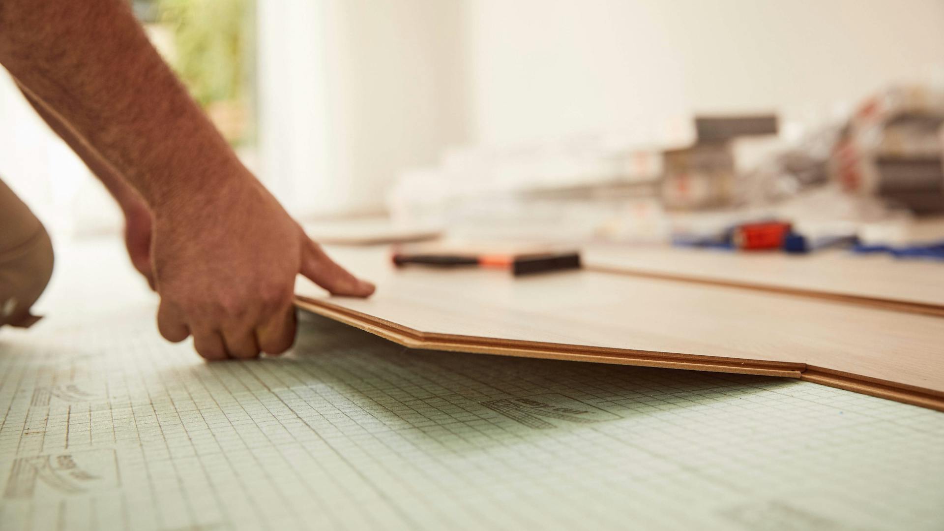 Klicklaminat wird von einem Heimwerker verlegt.